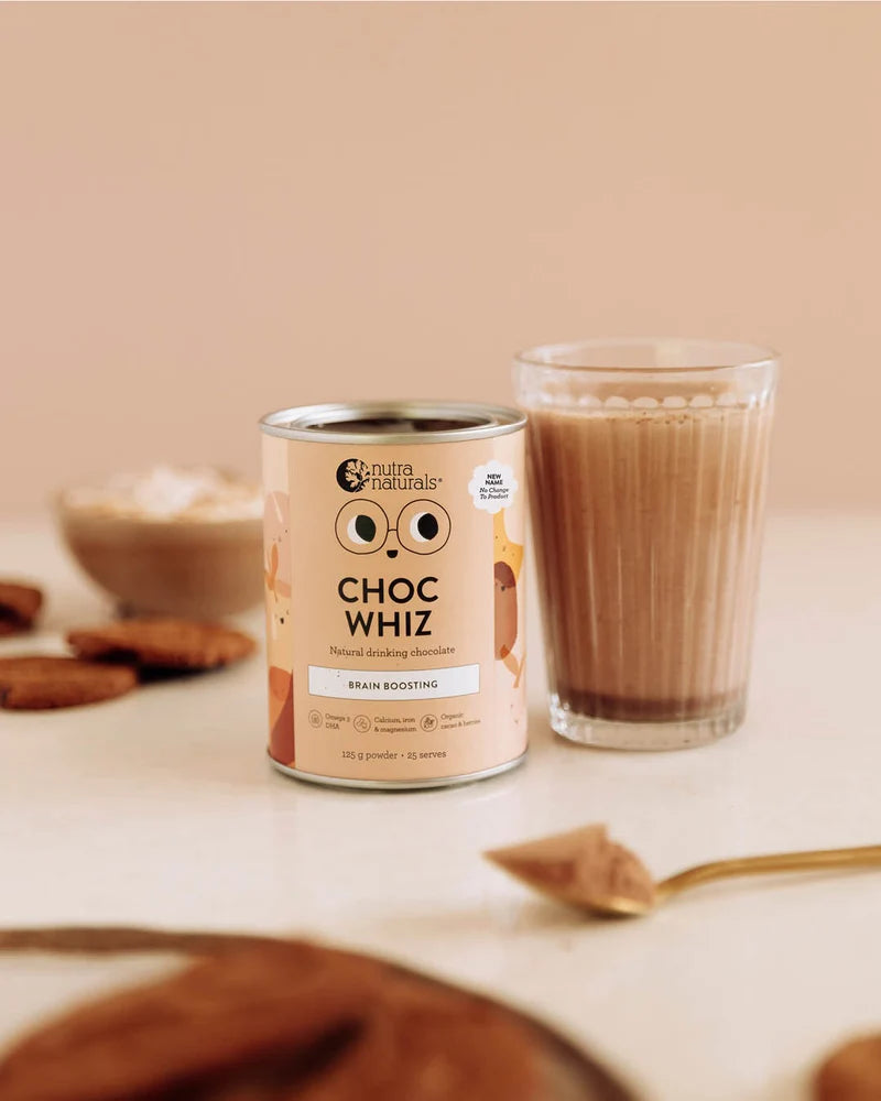 Can of Choc Whiz with a glass of chocolate milk on a beige background